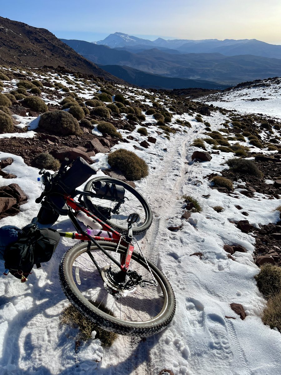 A loaded bicycle on snowy terrain during the Atlas Mountain Race